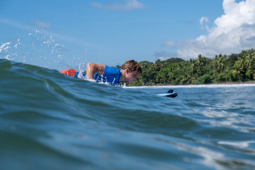 Popping up on a blue-green wave in Uvita, Osa, Costa Rica