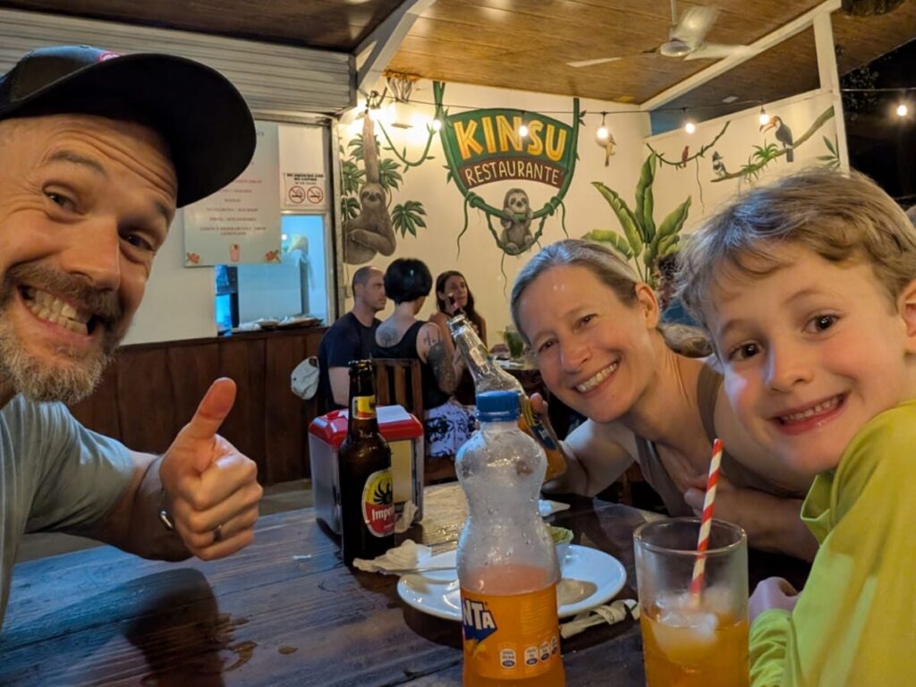 A family having dinner at a restaurant in Costa Rica during their family surf camp.