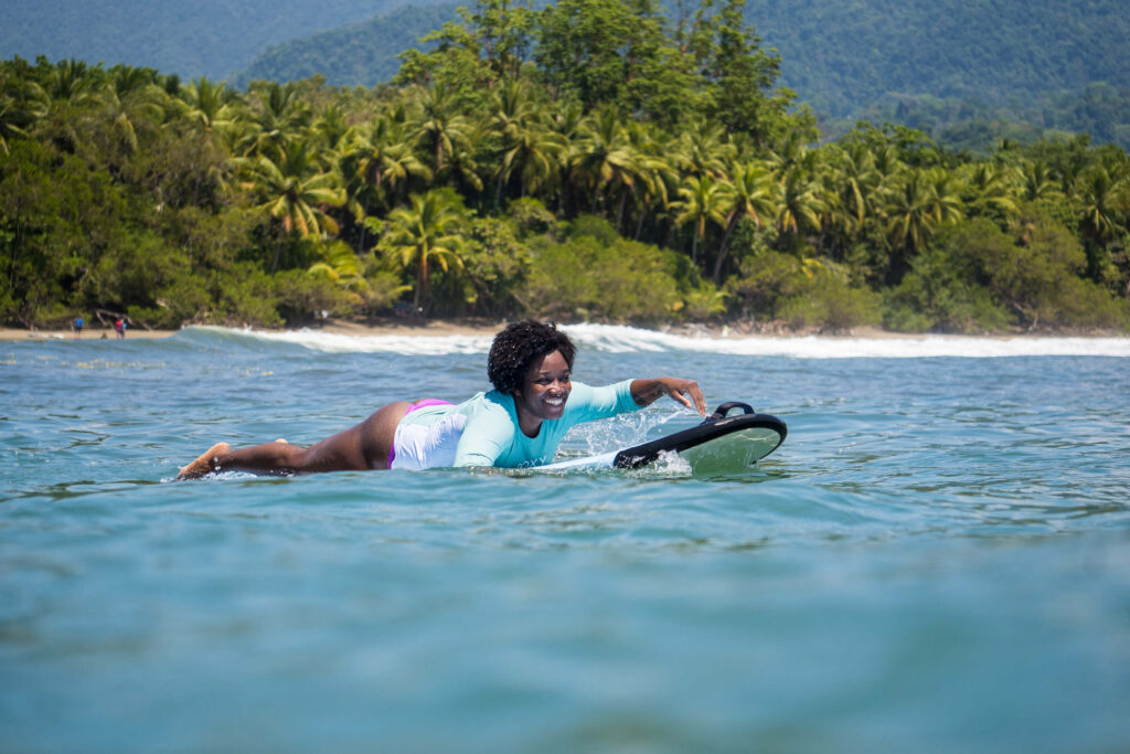 A surfer catching a wave in Uvita while focusing on the feel of the ocean instead of how they look to others.
