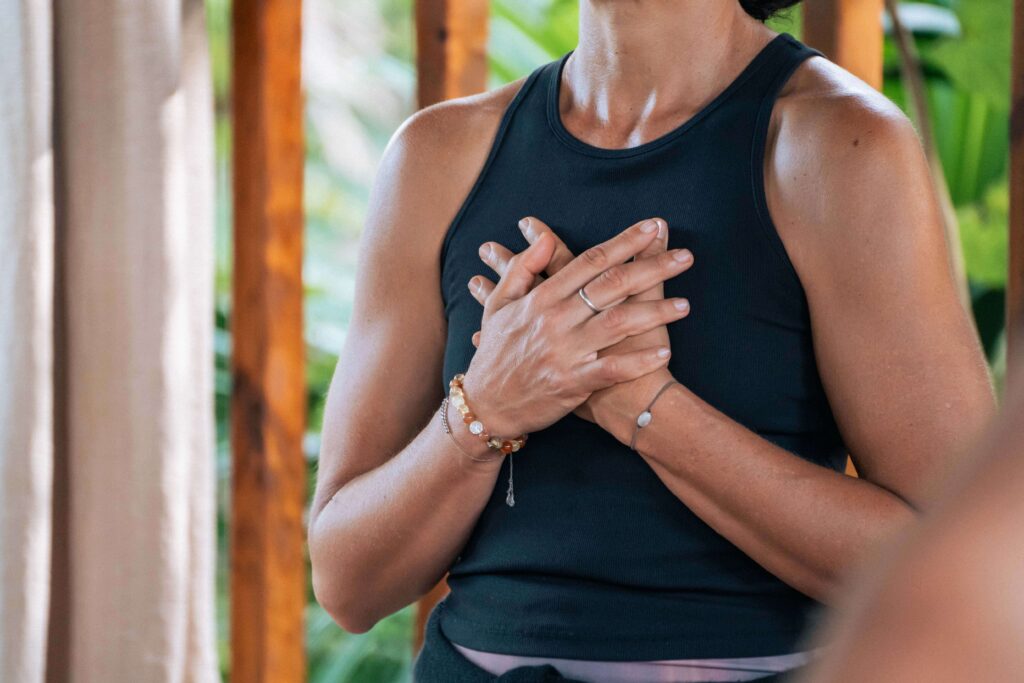 A student on the yoga deck in Costa Rica choosing a gentle modification to practice self-compassion during their session.