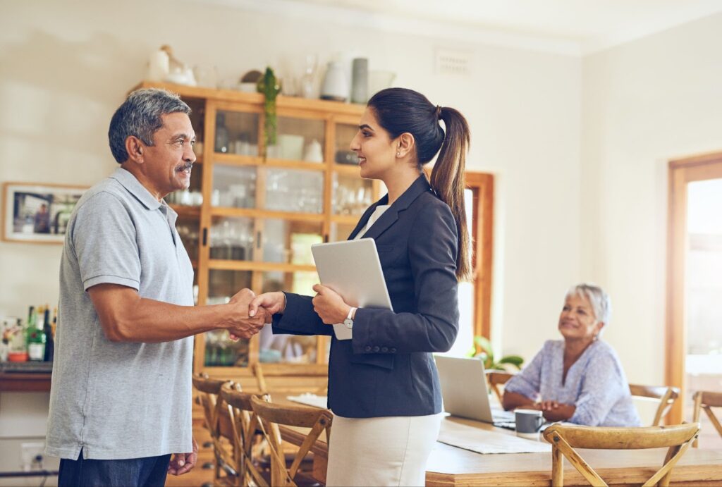 A property owner shaking hands with their tenant after informing them that the property is for sale.