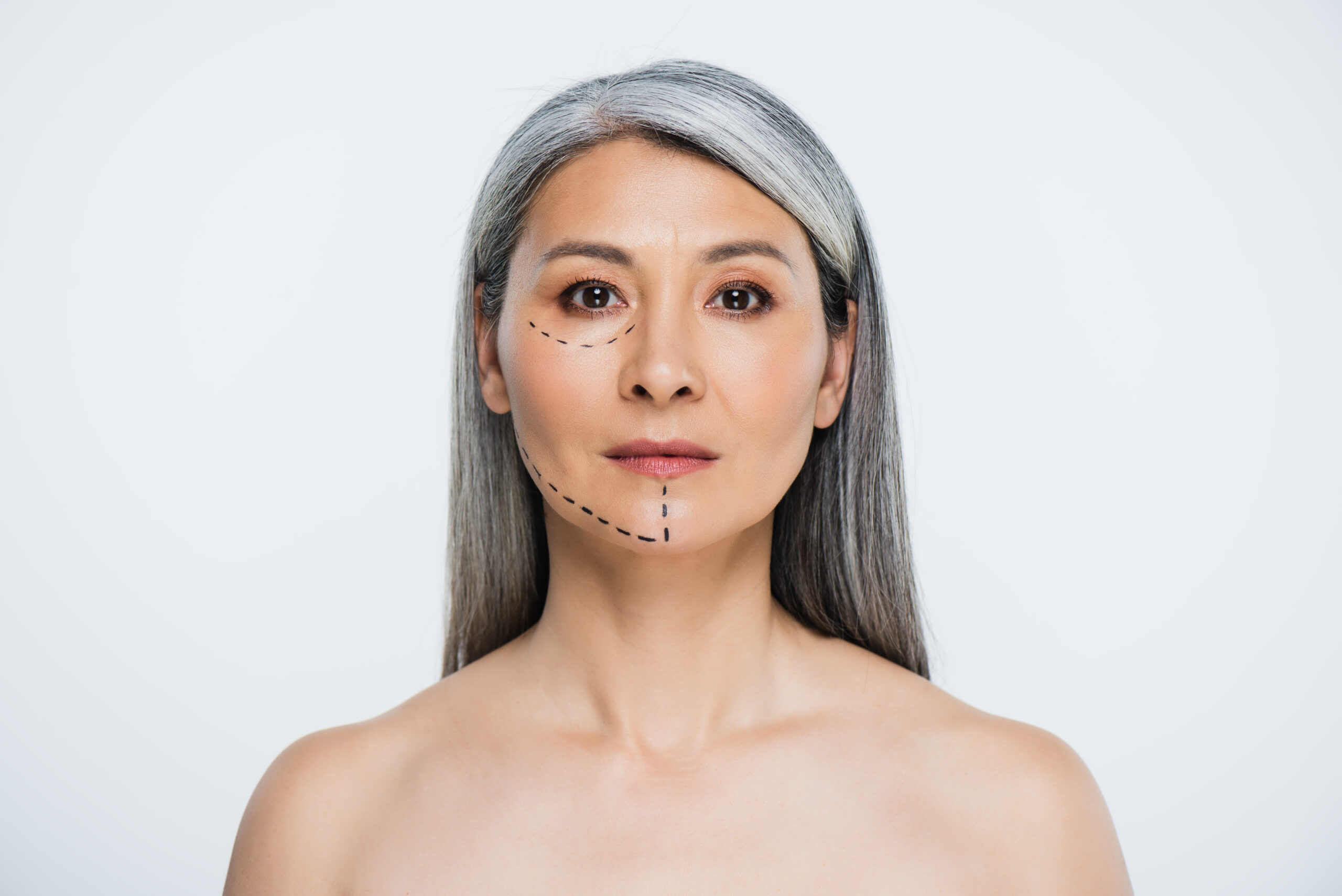 attractive naked asian woman with plastic surgery lines on face isolated on grey attractive naked asian woman with plastic surgery lines on face isolated on grey