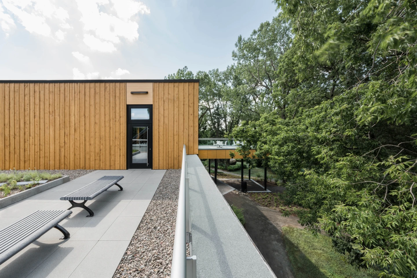 Extérieur du Pavillon d'accueil du Parcours Gouin, vue sur des bancs