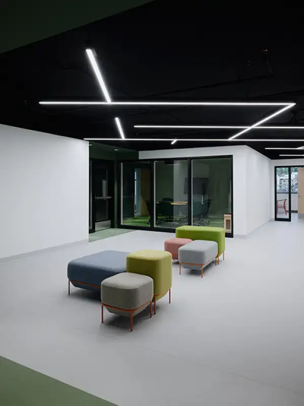 Espace commun du campus universitaire Concordia avec mobilier modulable, design intérieur contemporain et salles vitrées favorisant la collaboration.