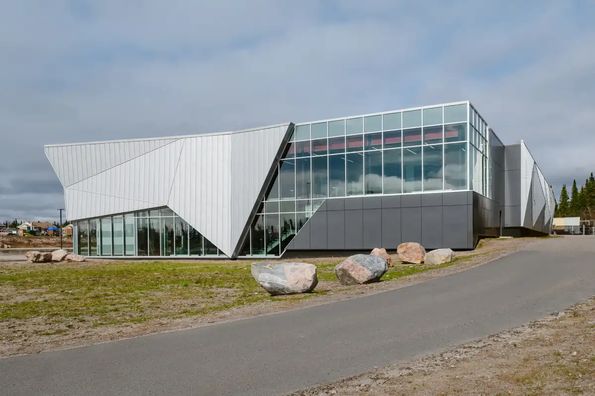 Vue extérieure de l’aréna de Wemindji, un bâtiment moderne avec une façade en verre et métal