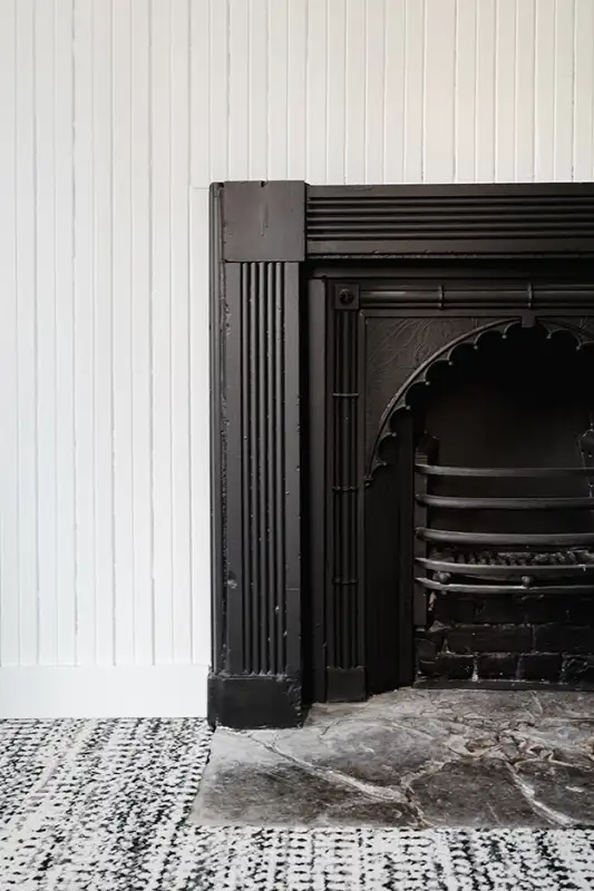 Foyer noir moderne créant un contraste élégant avec un mur blanc épuré dans un intérieur contemporain.
