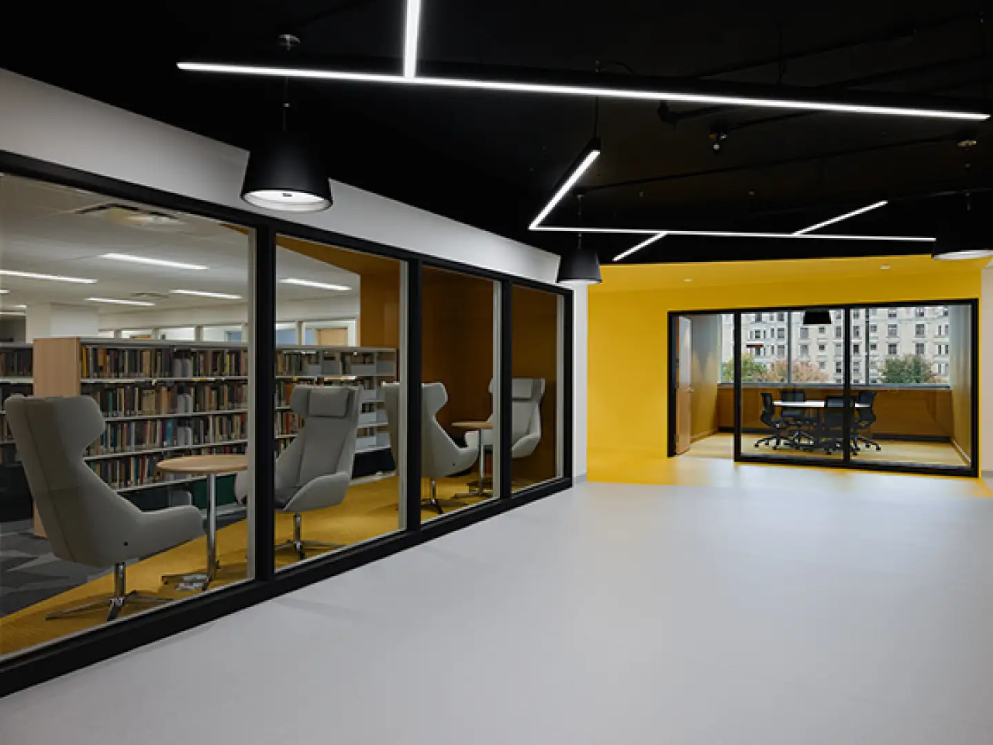 Zone d’étude et de collaboration au campus Concordia avec design intérieur moderne, salles vitrées et espaces de travail universitaire flexibles.