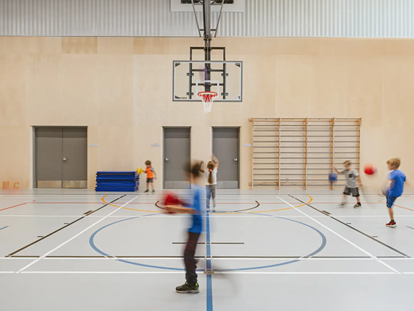 Élèves en activité dans le gymnase de l’École des Deux-Rivières, un espace sportif moderne conçu pour l’éducation physique et les activités scolaires.