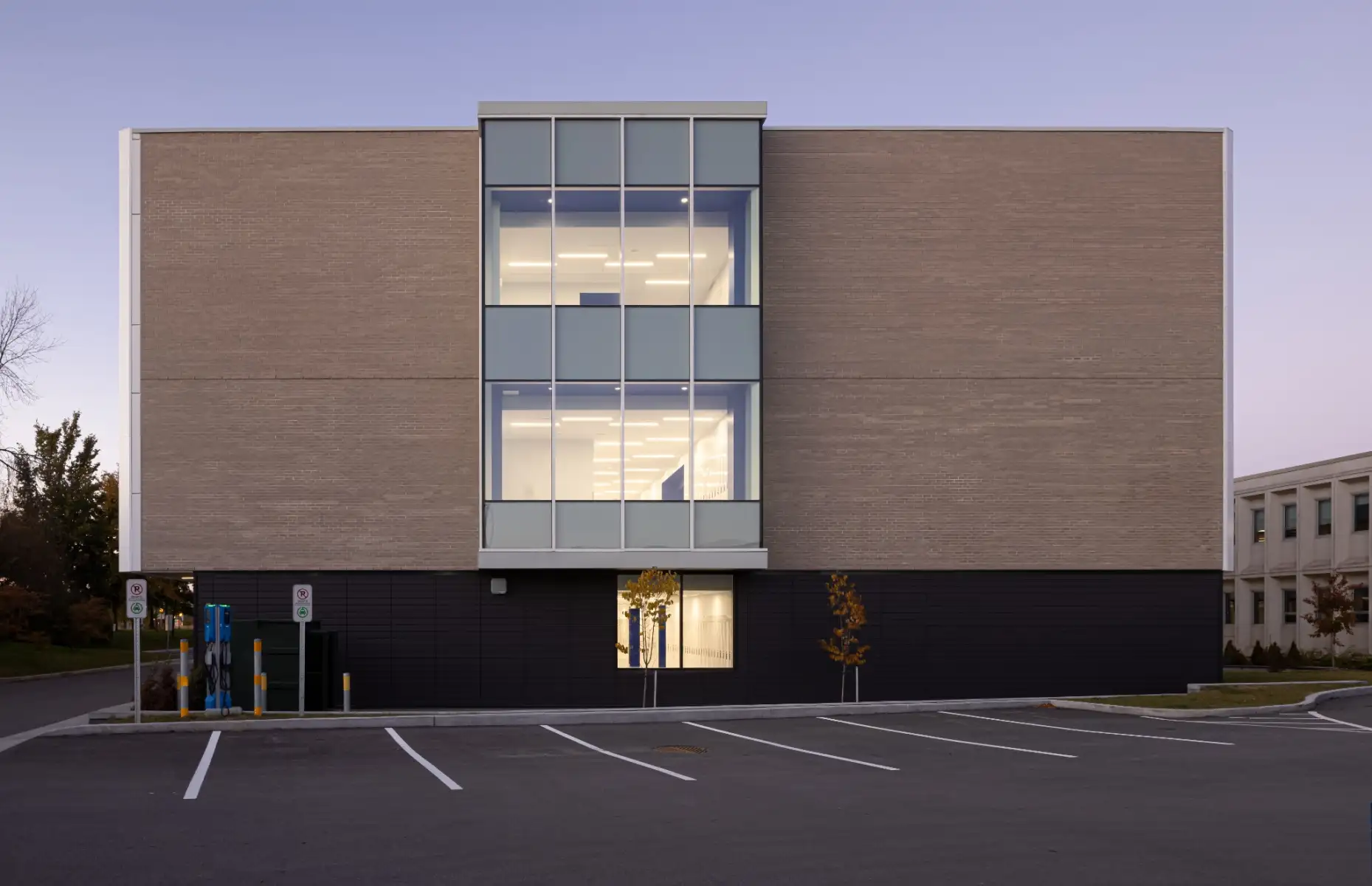 Façade arrière de l’École Cardinal-Roy présentant une architecture moderne en brique et verre avec espaces lumineux répartis sur plusieurs niveaux.