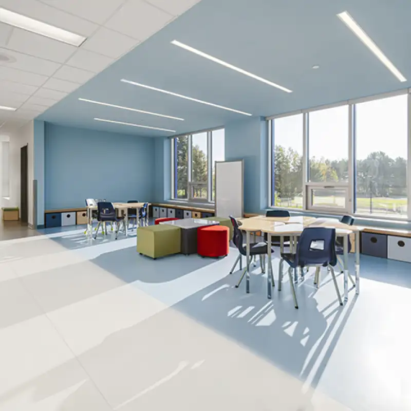 Espace d’apprentissage lumineux de l’École des Deux-Rivières avec mobilier flexible, grandes fenêtres et zones collaboratives favorisant la réussite scolaire.