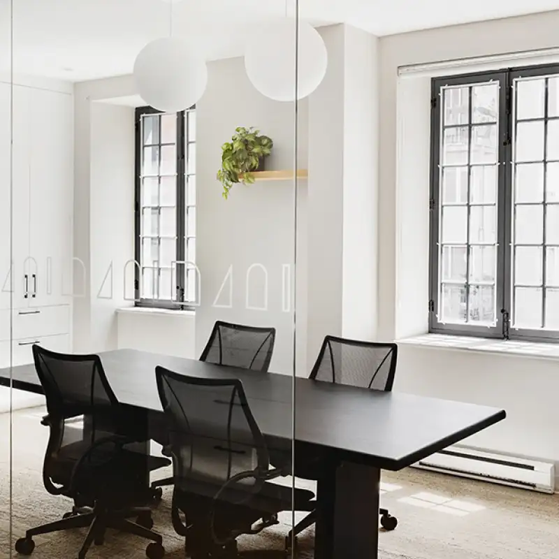 Salle de réunion moderne et lumineuse, aménagée avec une grande table et des chaises ergonomiques pour les rencontres professionnelles.