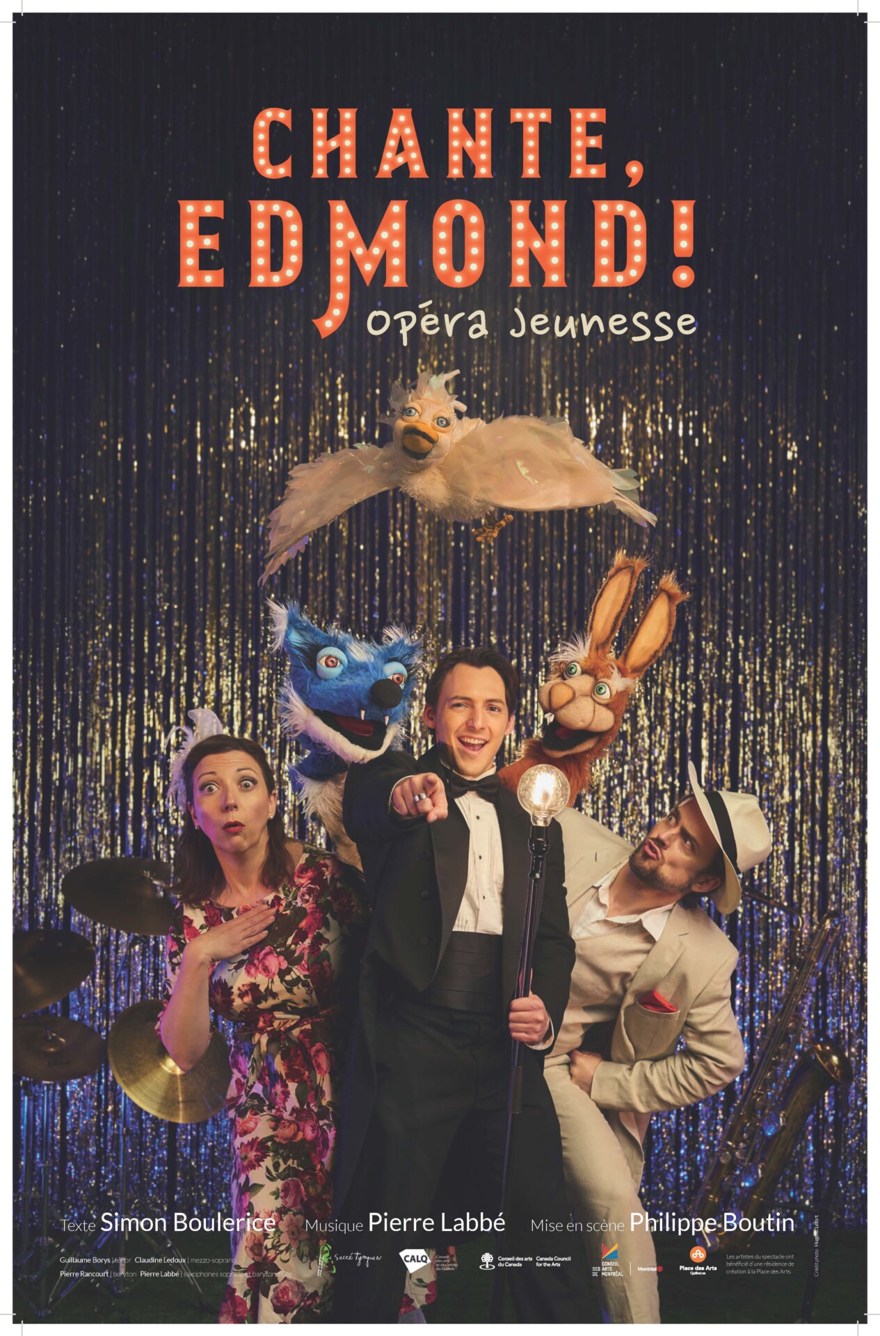 Affiche du spectacle "Chante, Edmond!". Trois artistes, à gauche une femme avec une robe fleurie, au centre un homme avec un tuxedo noir et blanc, à droite un homme avec un complet beige. Derrière et au-dessus d'eux, trois marionnettes d'animaux.
