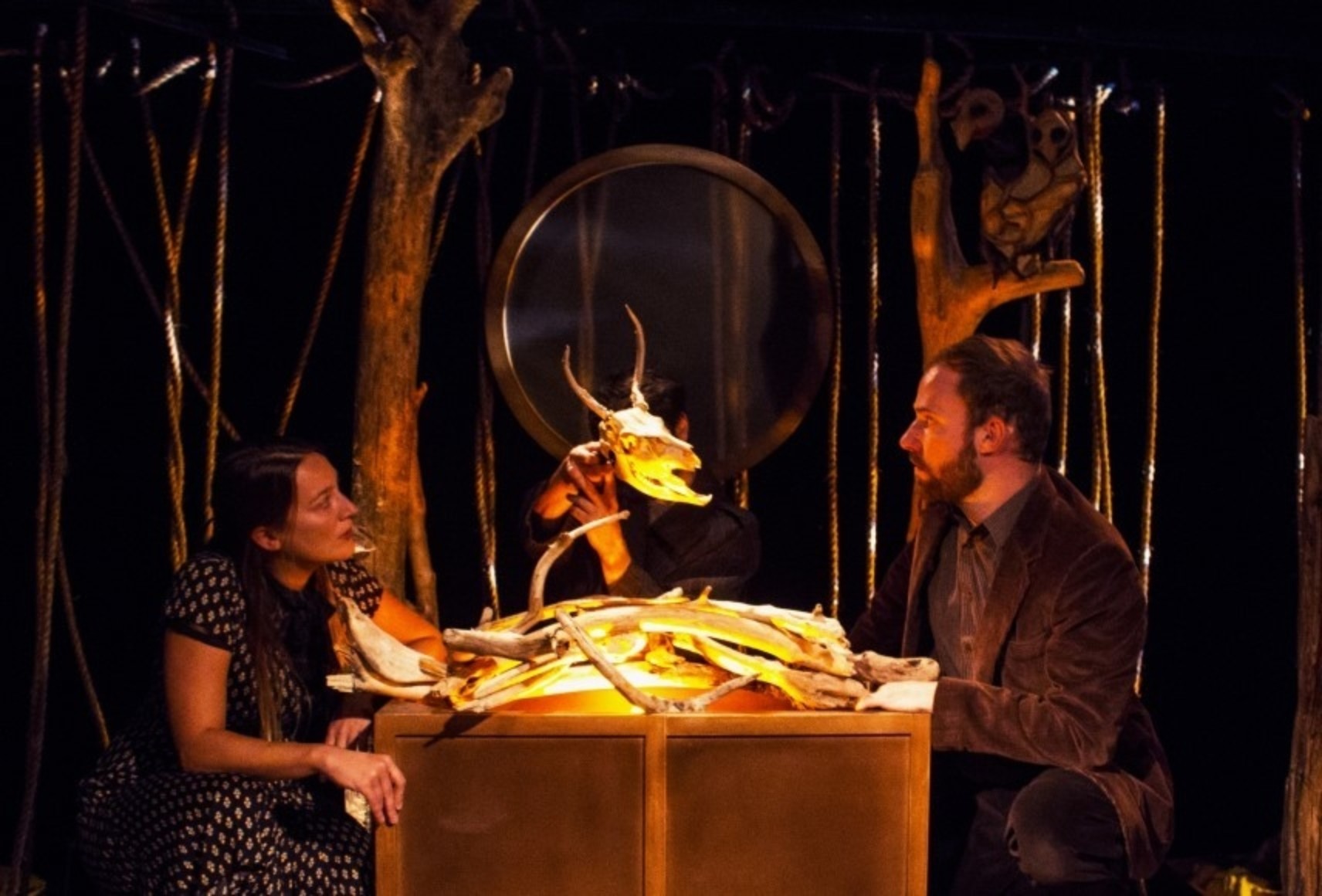 Photo de trois personnages assis à une table