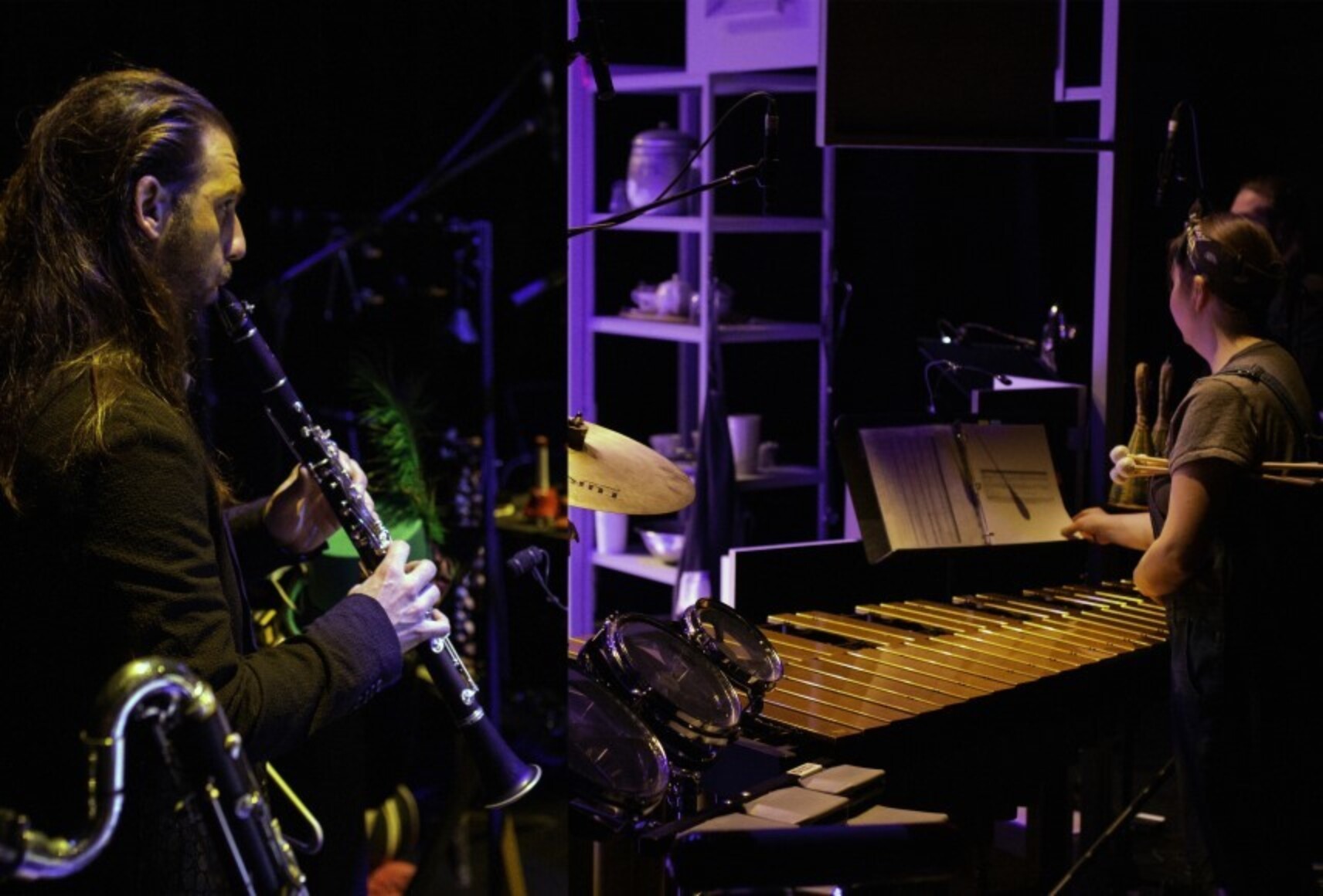 Photo en clair-obscur d'un musicien qui joue de la clarinette et d'une musicienne qui fait des percussions. D'autres instruments autour sont faiblement éclairés.