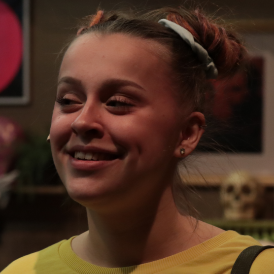 Photo de Jade. Elle a un chignon, la peau claire et sourit.