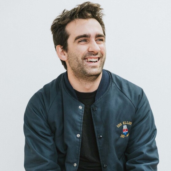 Portrait du comédien Jonathan Hardy, yeux verts, cheveux noirs ébouriffés et sourire contagieux