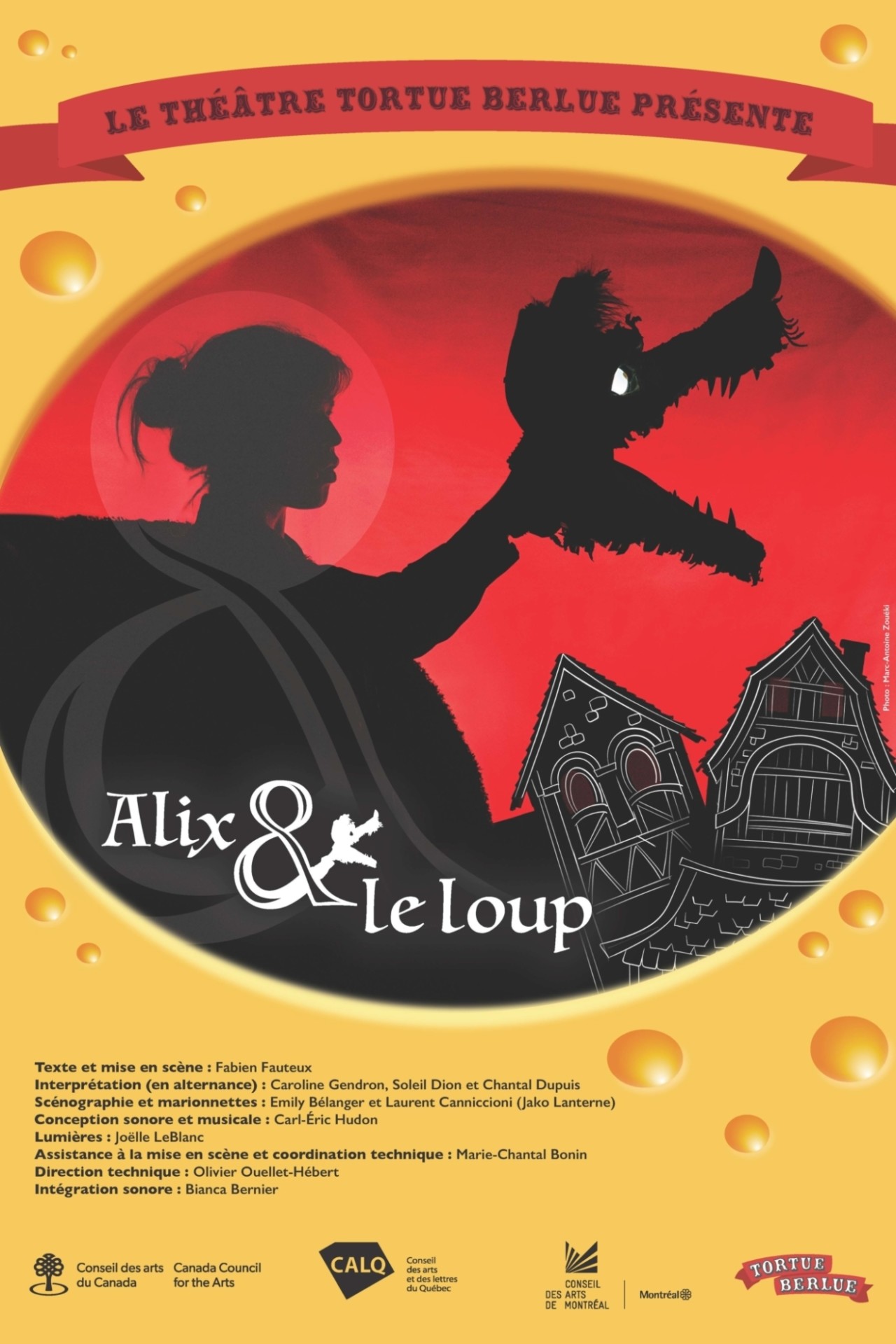 Affiche du spectacle "Alix & le loup". Sur fond jaune rappelant un fromage, dessin en noir, dans un cercle, d'une silhouette de fille tenant une marionnette de loup, la gueule ouverte. Le fond est rouge avec des maisons noires aux contours blancs.