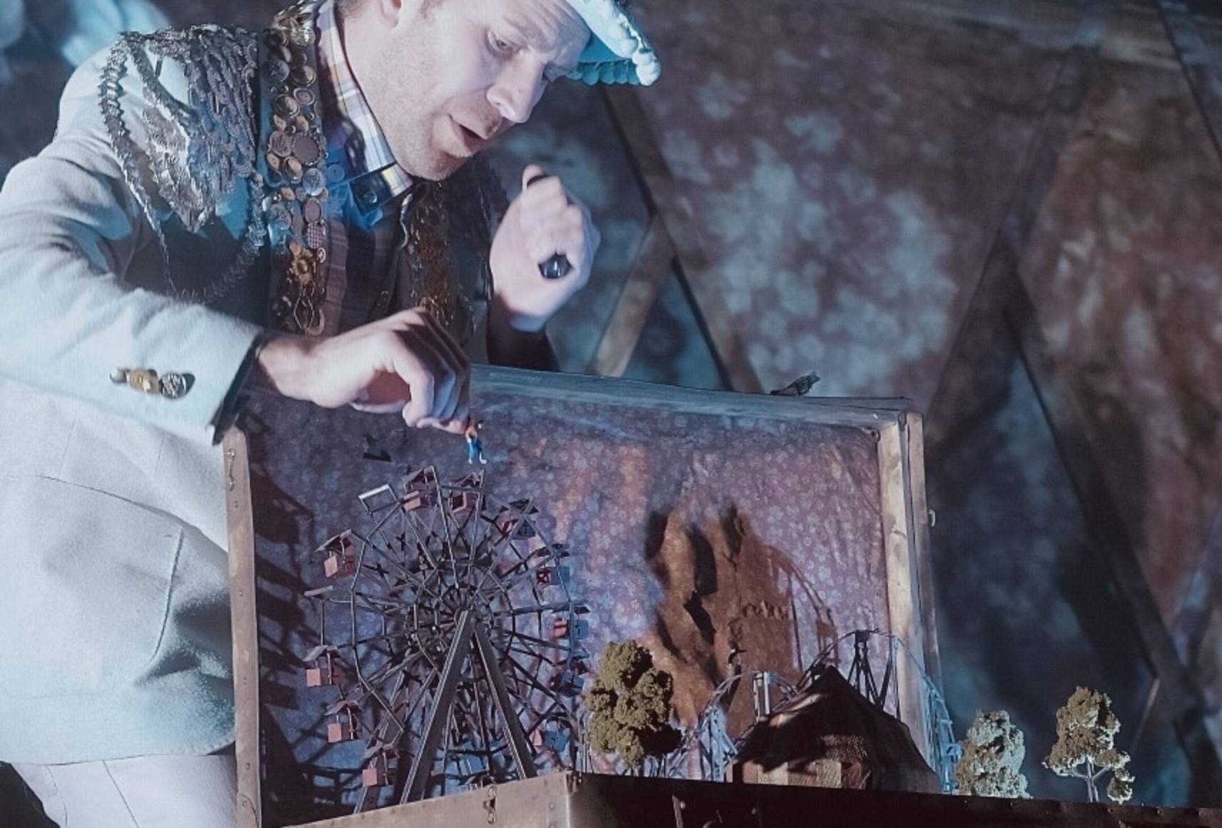 Photo d'un comédien tenant une maquette de parc dans les bras